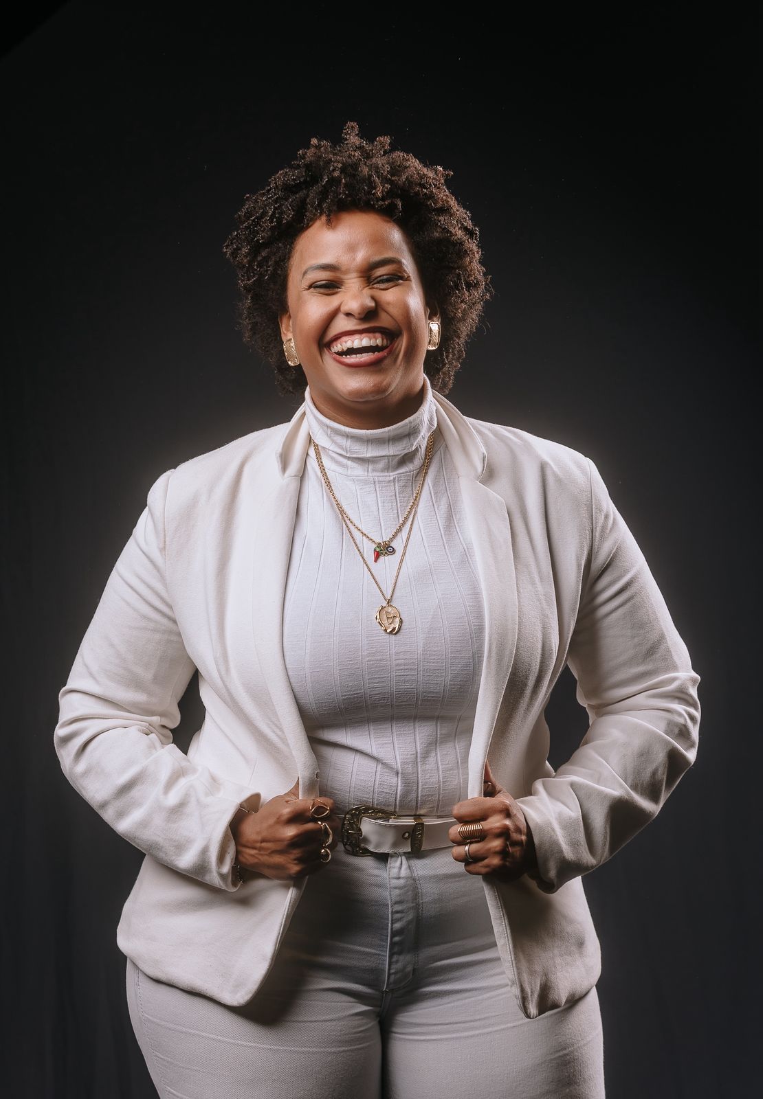 Retrato sorridente de Fernanda Silva com blazer branco